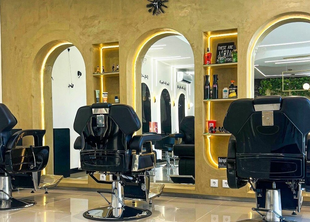 Interior elegante do The Mani Pedi Spa Maputo com cadeiras pretas e espelhos sofisticados em Maputo, Maputo, MZ.