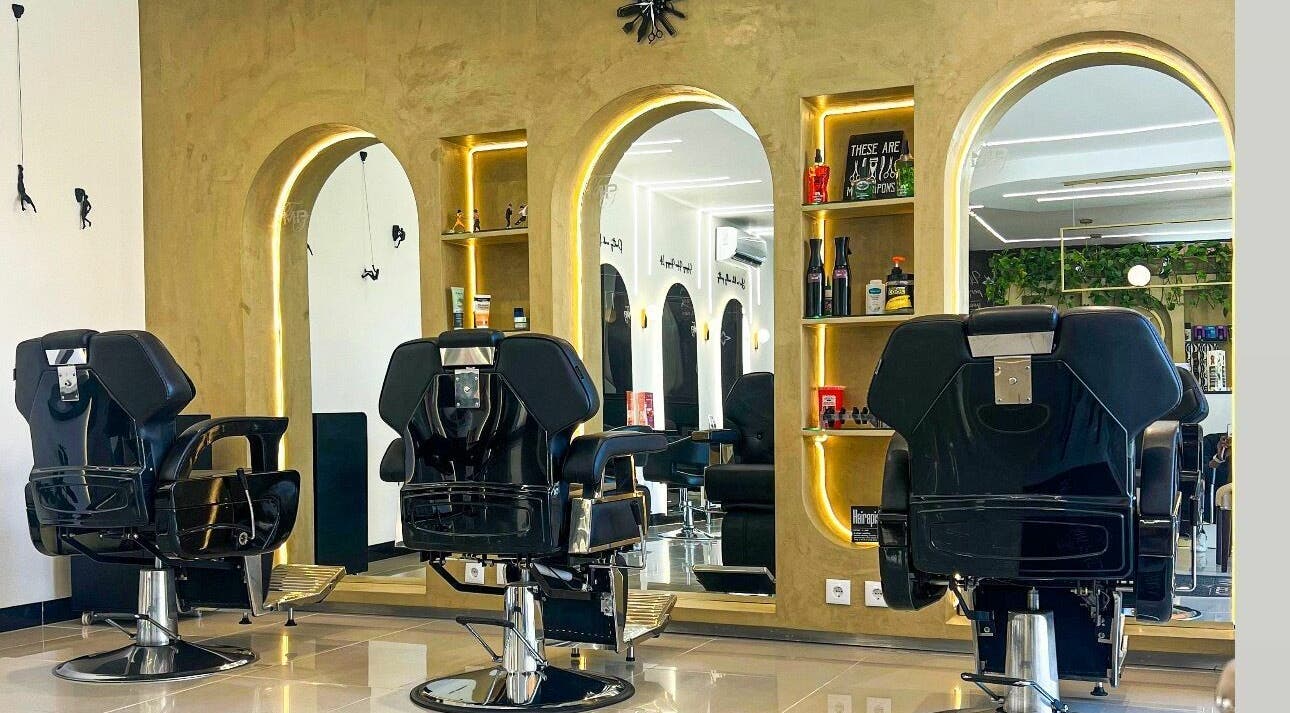 Interior elegante do The Mani Pedi Spa Maputo com cadeiras pretas e espelhos sofisticados em Maputo, Maputo, MZ.