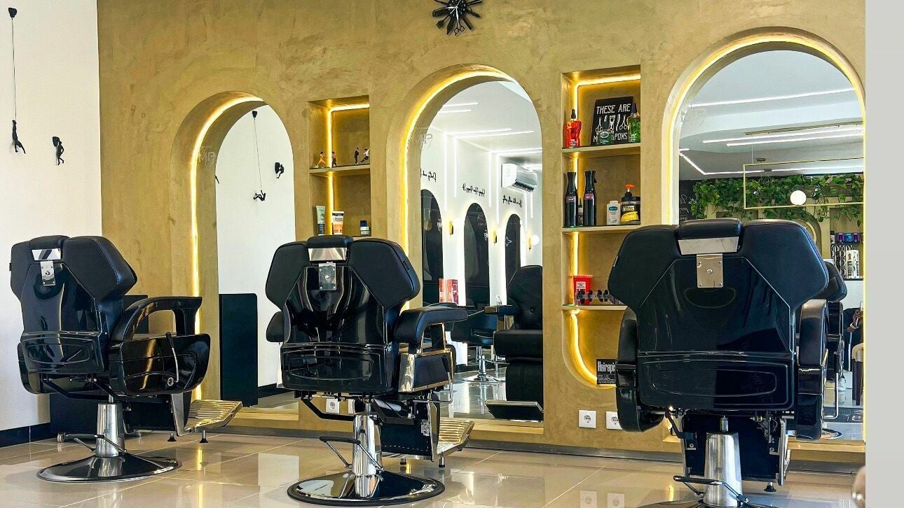 Interior elegante do The Mani Pedi Spa Maputo com cadeiras pretas e espelhos sofisticados em Maputo, Maputo, MZ.