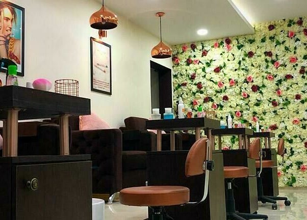 Interior elegante do The Mani Pedi Spa Matola, Matola, Maputo, MZ, com decoração floral vibrante nas paredes.