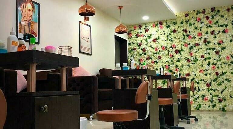 Interior elegante do The Mani Pedi Spa Matola, Matola, Maputo, MZ, com decoração floral vibrante nas paredes.