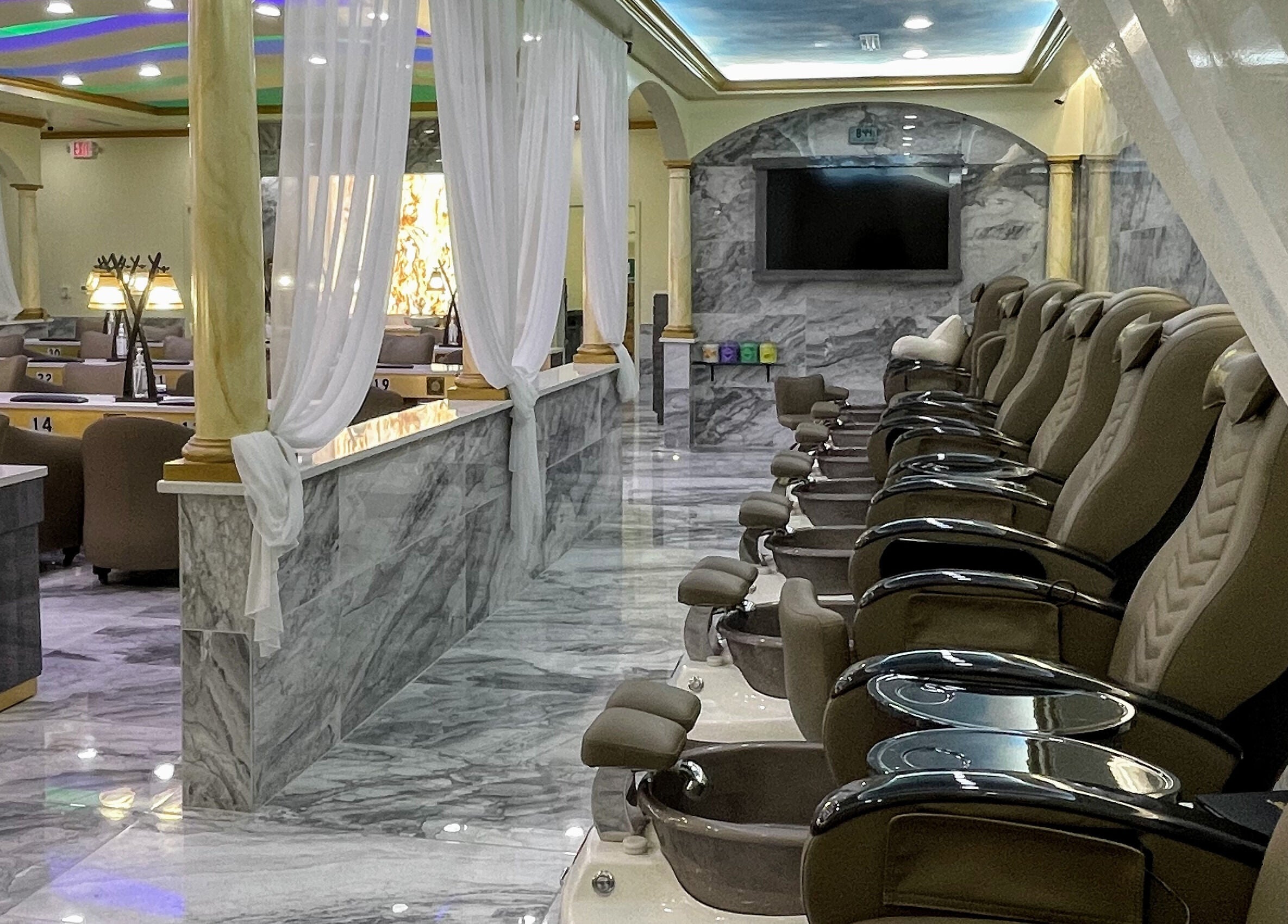 Elegant interior of Luminous V Nail Spa in Springboro, Ohio, US with plush pedicure chairs and marble decor.
