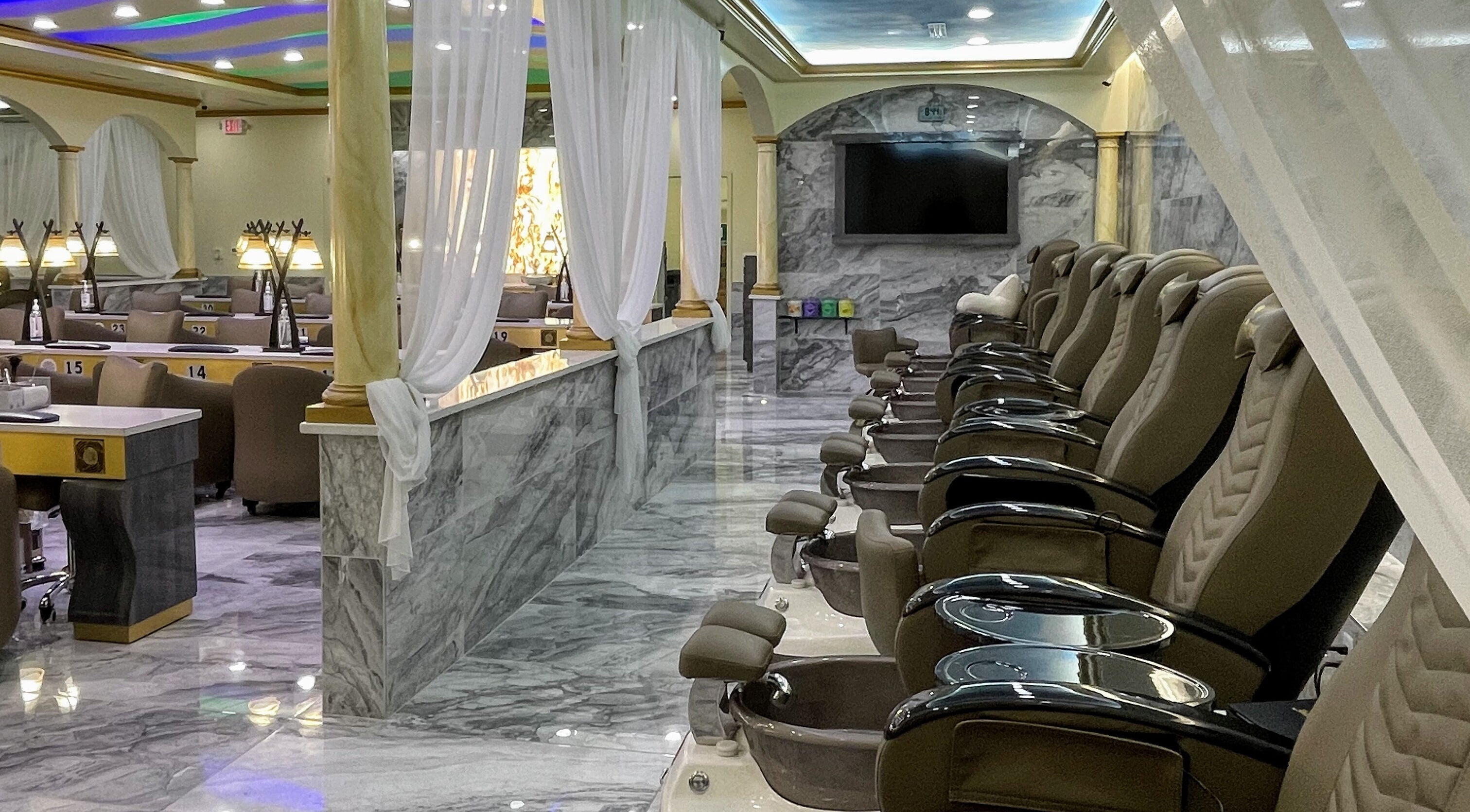 Elegant interior of Luminous V Nail Spa in Springboro, Ohio, US with plush pedicure chairs and marble decor.