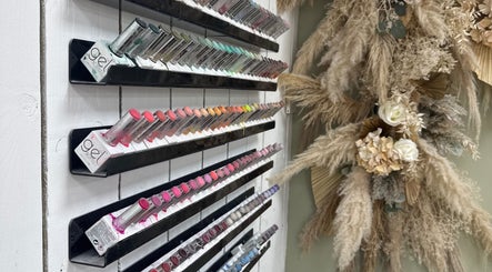 Colorful nail polish display at Nails by Lia in Wednesbury, England, GB next to elegant floral decor.