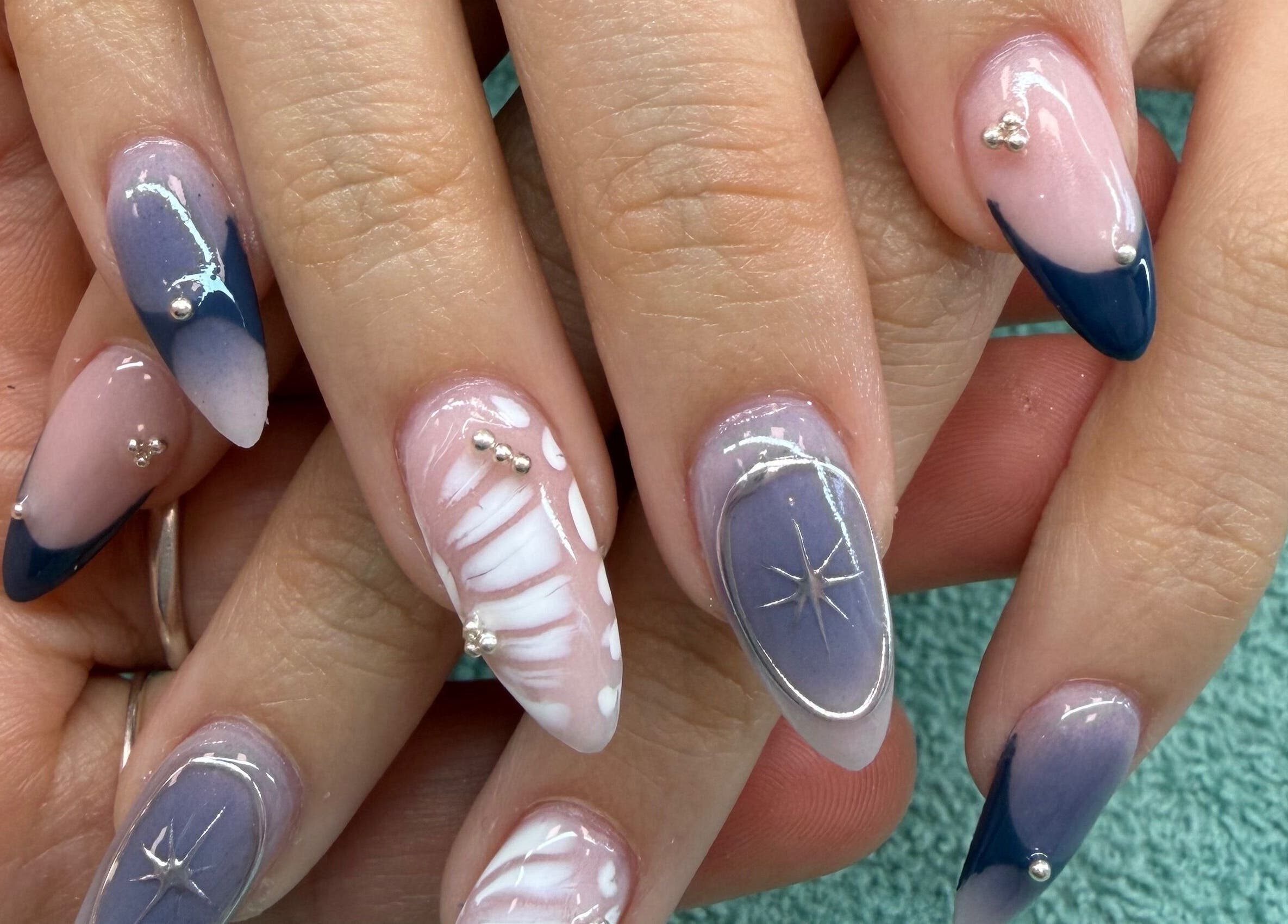 Elegant nail designs at Monserrat Nails, Kenosha, Wisconsin, US featuring blue and white patterns.