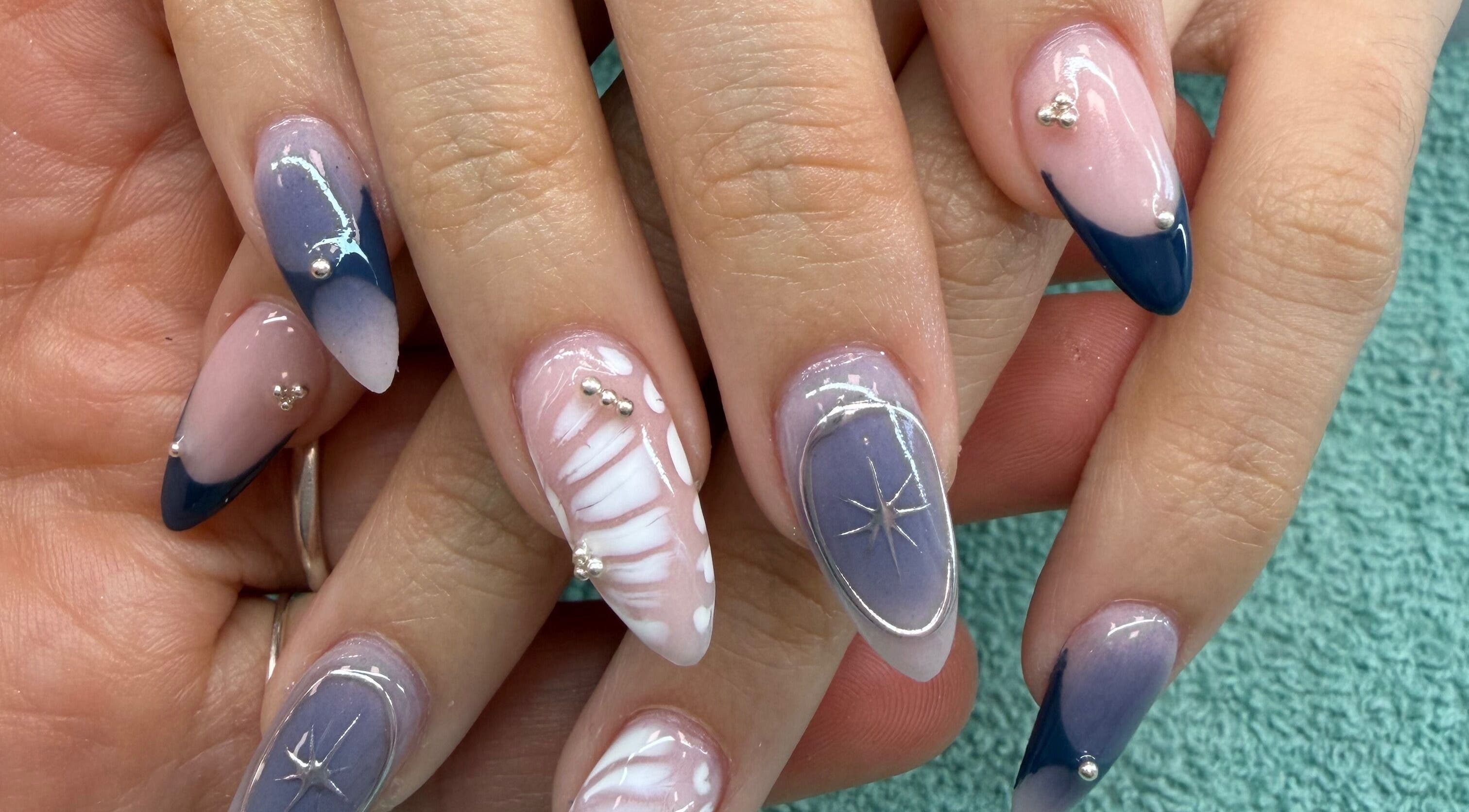 Elegant nail designs at Monserrat Nails, Kenosha, Wisconsin, US featuring blue and white patterns.