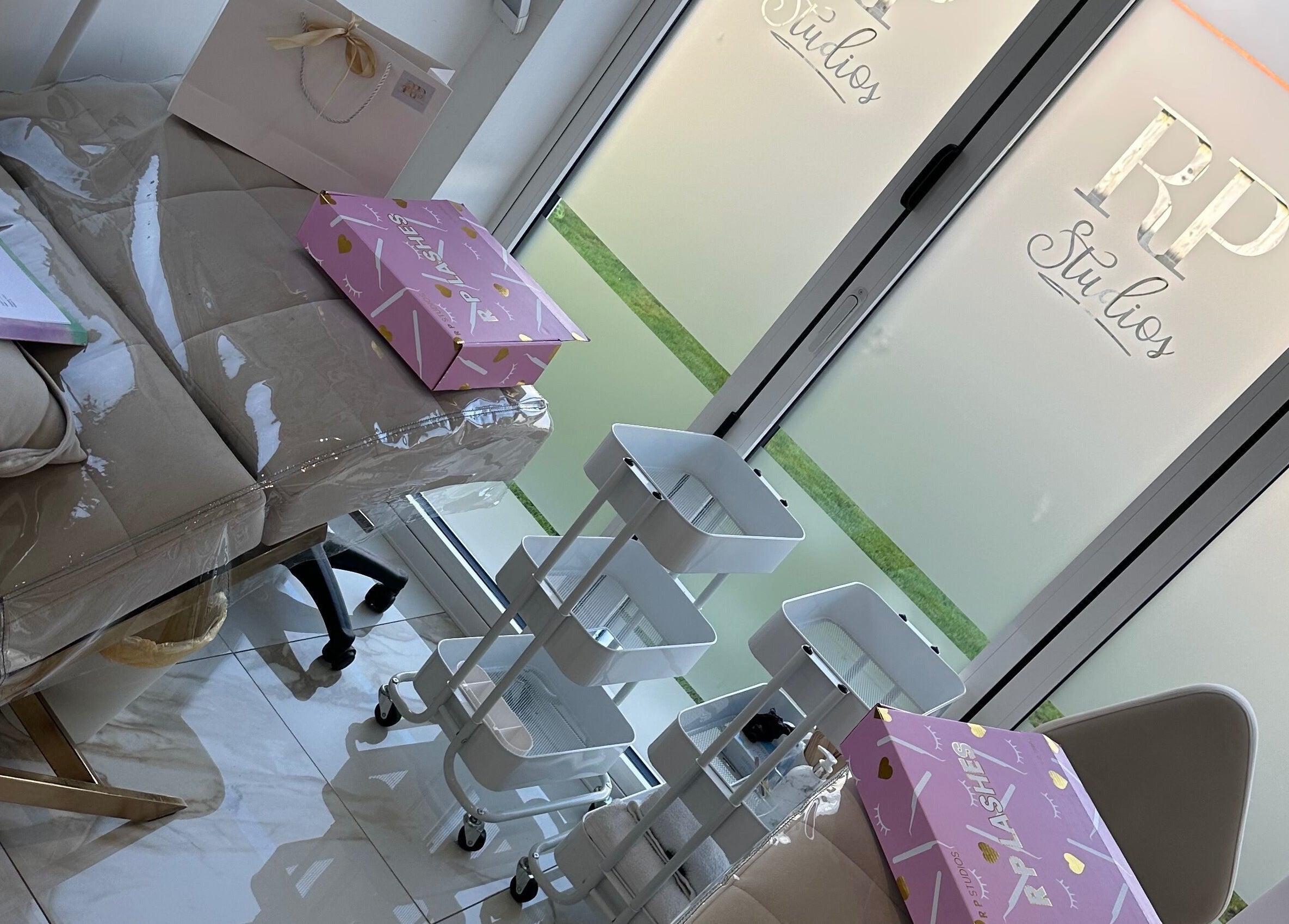 Elegant treatment room at RP Studios, Milnrow, England, GB featuring a cushioned bed and white shelving.