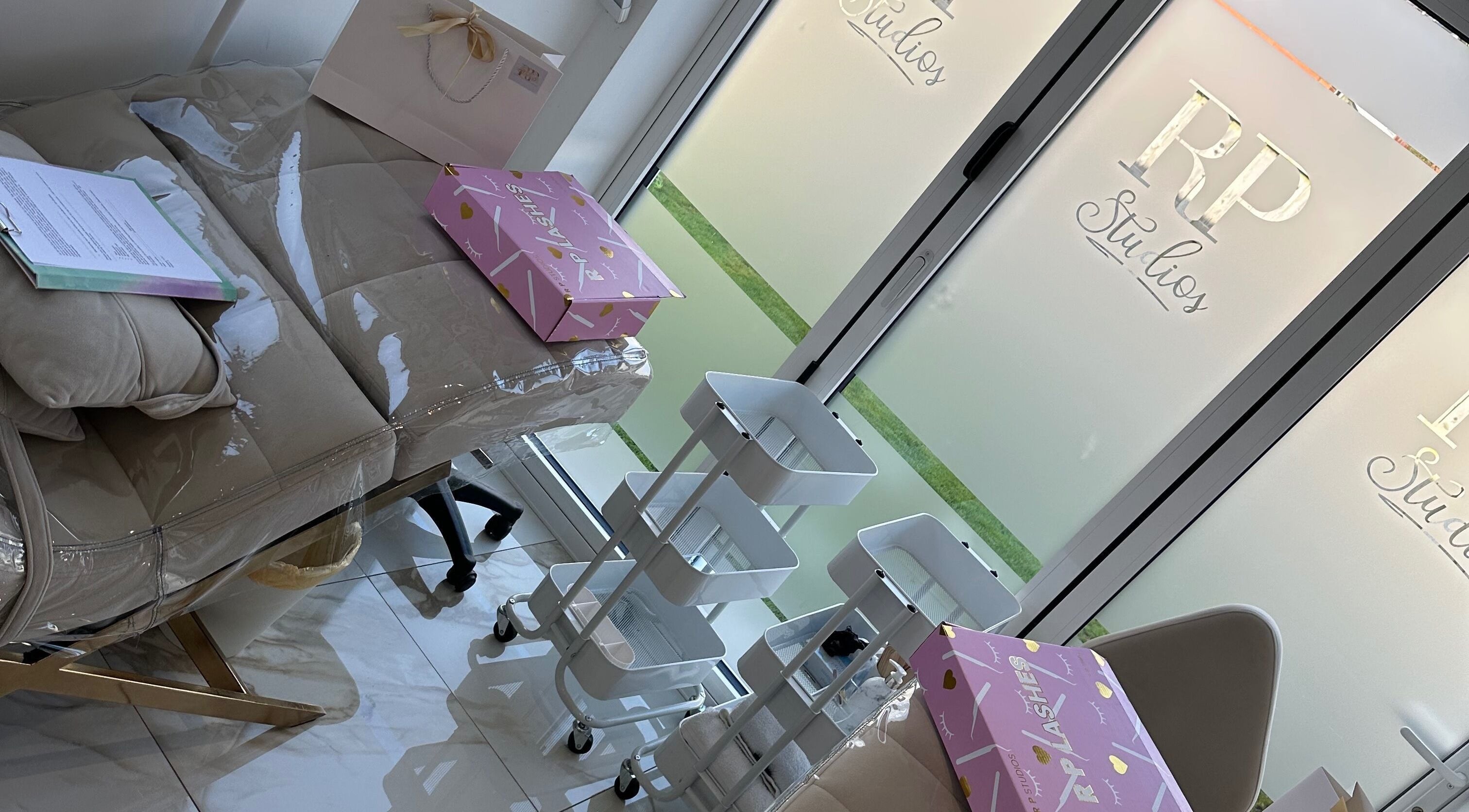 Elegant treatment room at RP Studios, Milnrow, England, GB featuring a cushioned bed and white shelving.