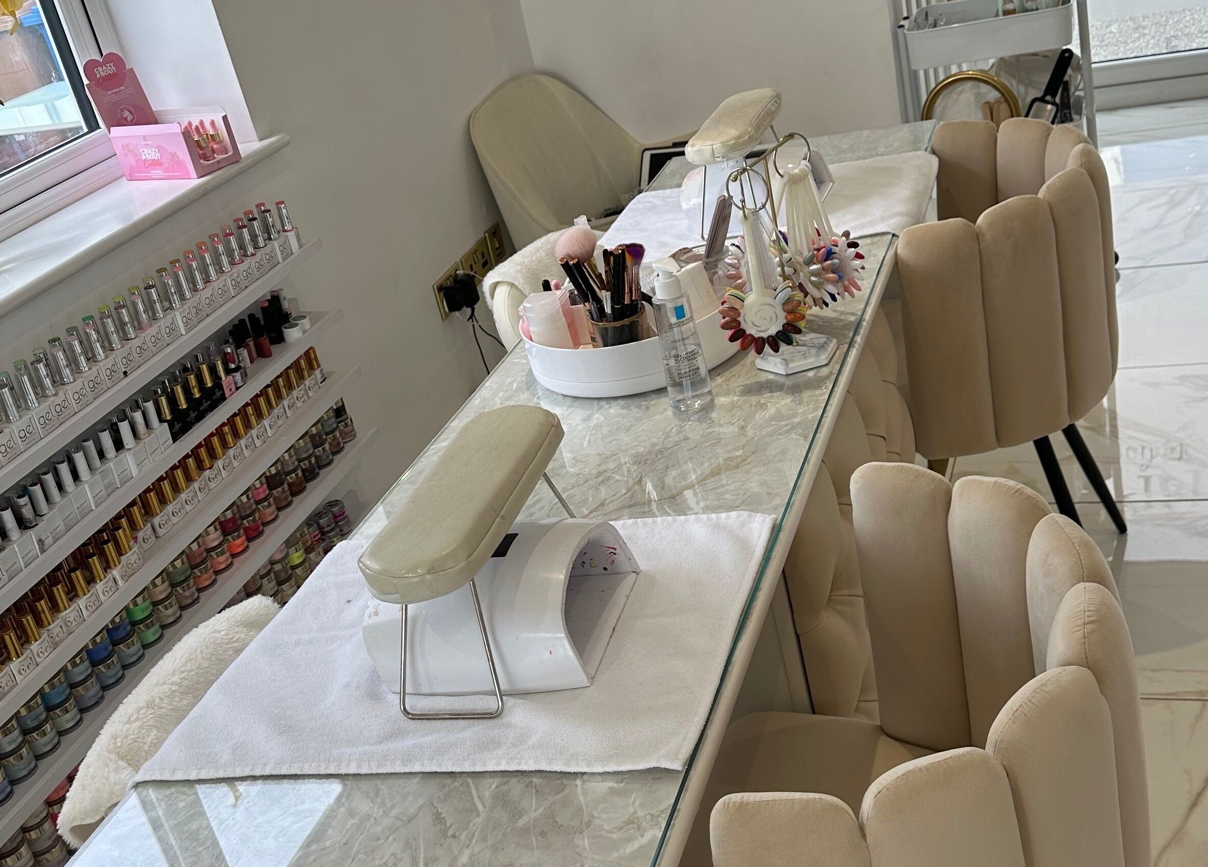 Ultra-modern nail salon setup at RP Studios in Milnrow, England, GB with elegant chairs and nail polish display.