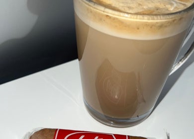 A creamy latte and a biscuit served at RP Studios, Milnrow, England, GB.