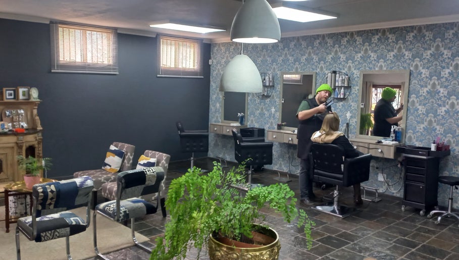 Hairstylist at New Millennium Hair Studio, Lydenburg, Mpumalanga, ZA creating modern haircut in stylish interior.