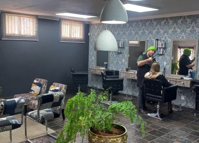 Hairstylist at New Millennium Hair Studio, Lydenburg, Mpumalanga, ZA creating modern haircut in stylish interior.