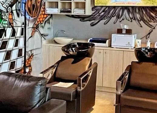 Contemporary styling chairs at Barber Bros, Dubai, AE with modern graffiti art on the wall.