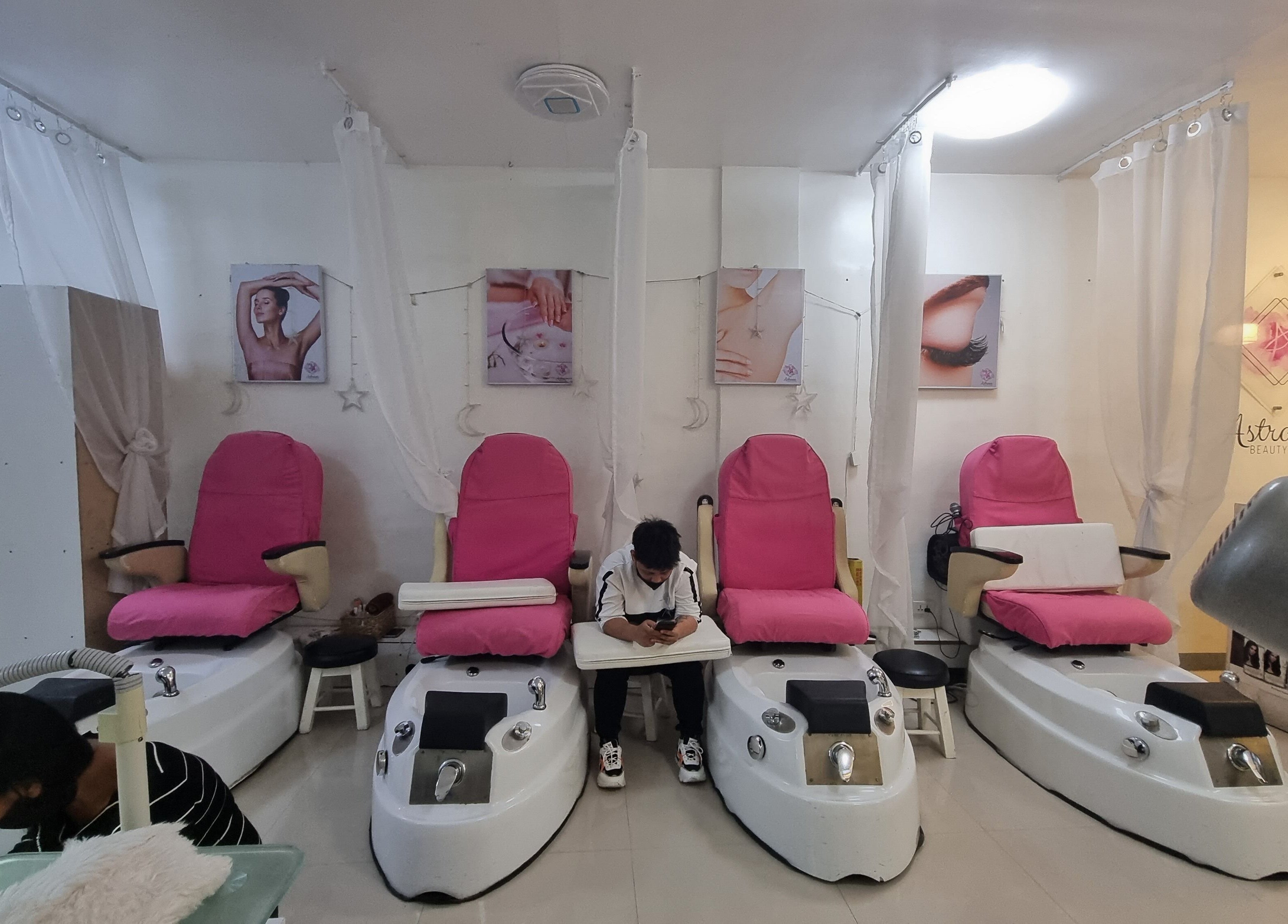 Astraea Beauty Salon pedicure area with pink chairs in Las Pinas, Metro Manila, PH for pampering and relaxation.