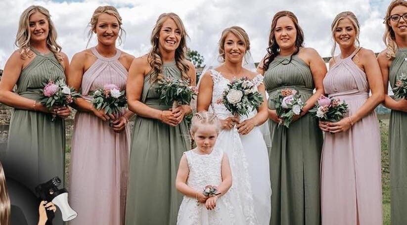 Bridal party smiling outdoors at The Tanning Room, Hall Green, England, GB, celebrating with bouquets.