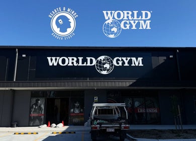 Front view of World Gym - Hearts & Minds Barber Studio at Tuggerah, New South Wales, AU under a clear sky.