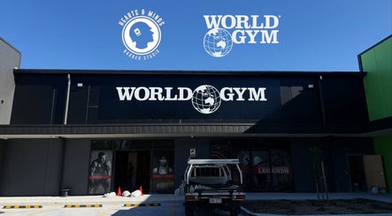 Front view of World Gym - Hearts & Minds Barber Studio at Tuggerah, New South Wales, AU under a clear sky.