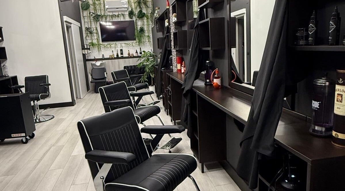 SherdanaTopBarber Quartu Viale Colombo a Quartu Sant'elena, Sardegna, IT. Interno moderno con poltrone nere.