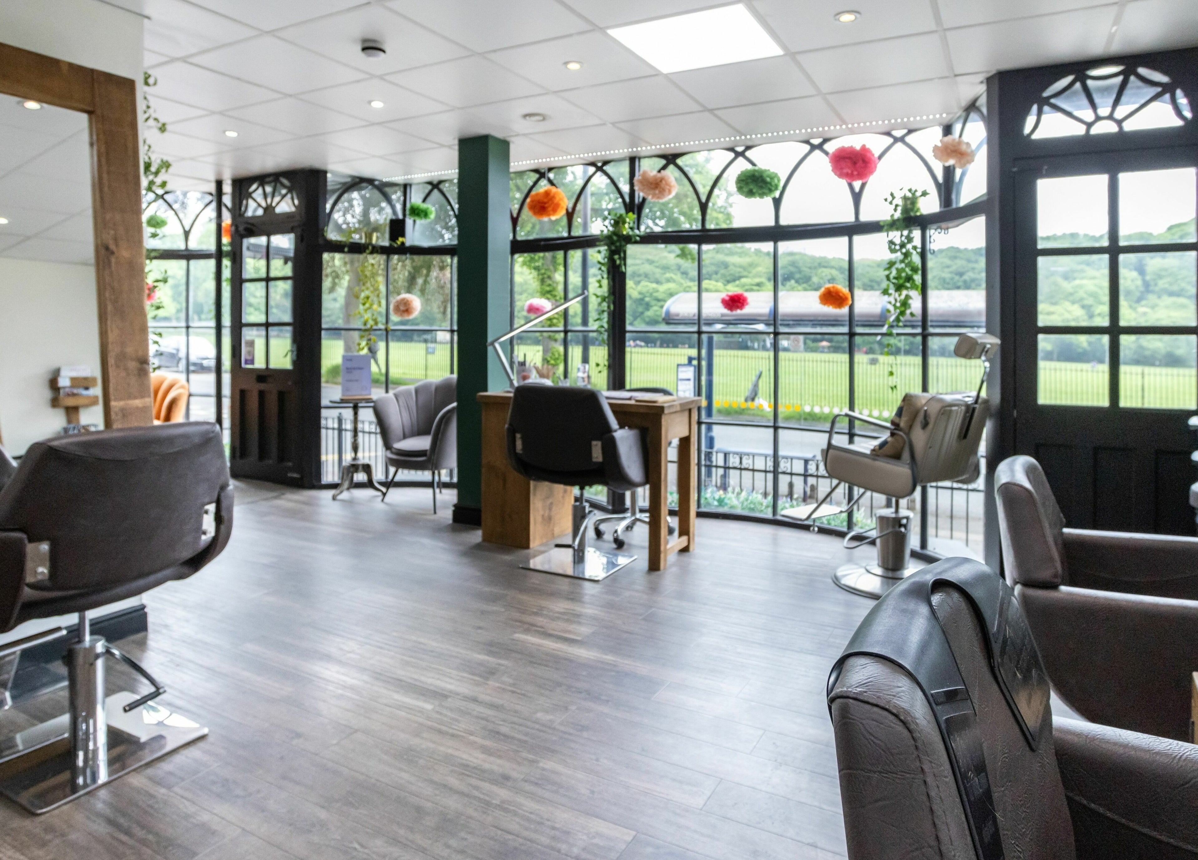 Modern salon interior at Headlines Elite, Sheffield, England, GB, featuring stylish decor and open windows.