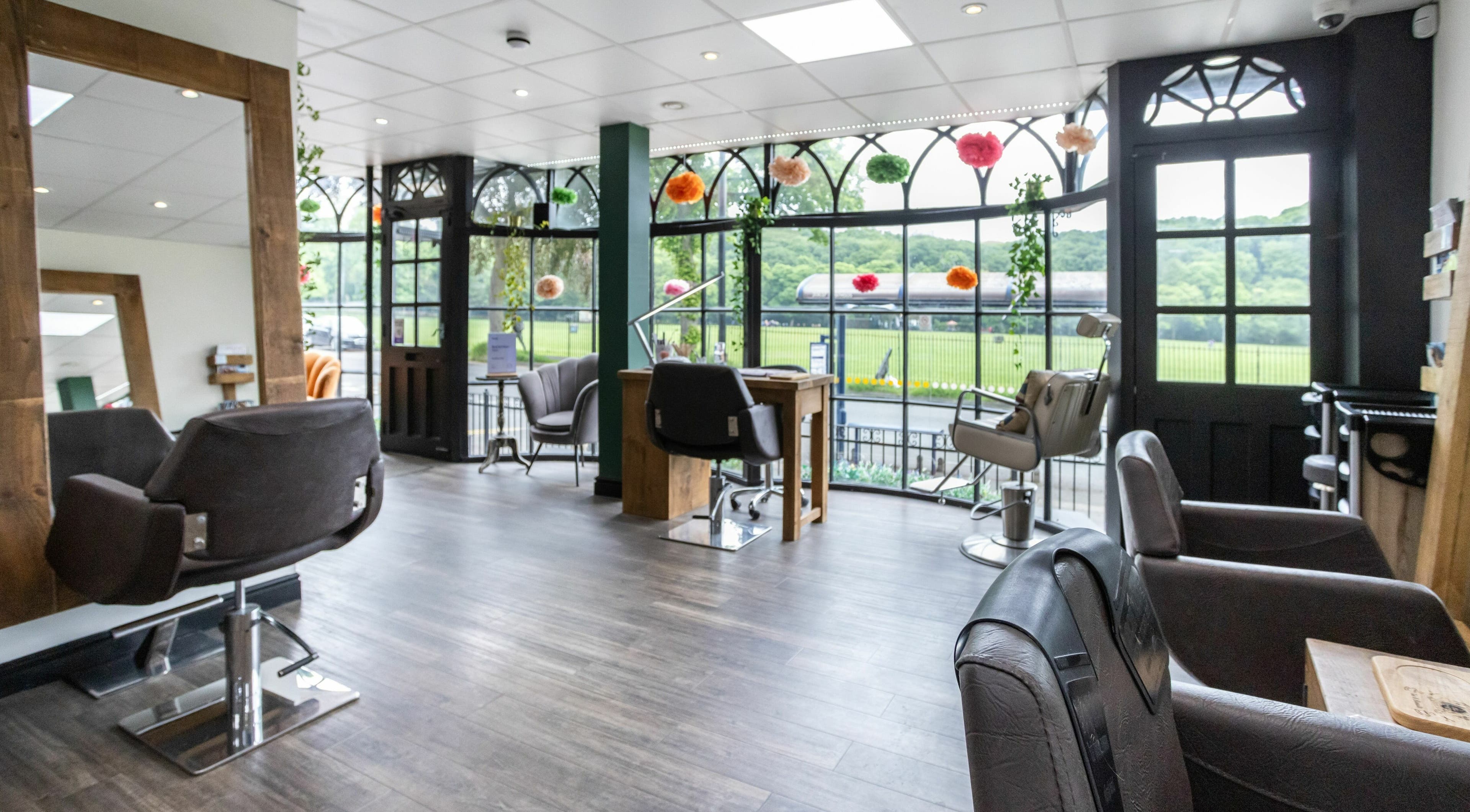 Modern salon interior at Headlines Elite, Sheffield, England, GB, featuring stylish decor and open windows.