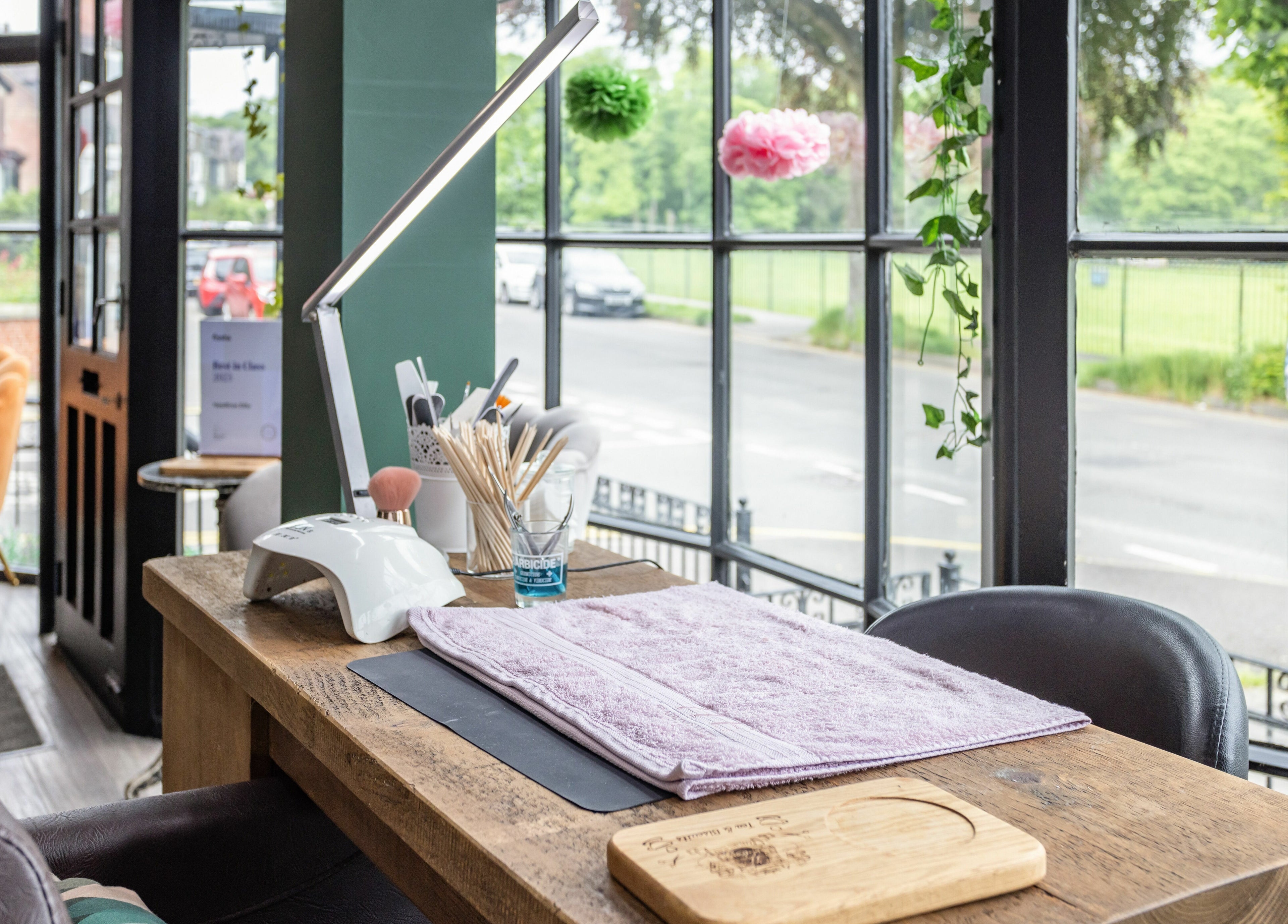 Cozy nail station at Headlines Elite in Sheffield, England, GB, with tools and a view of the street.