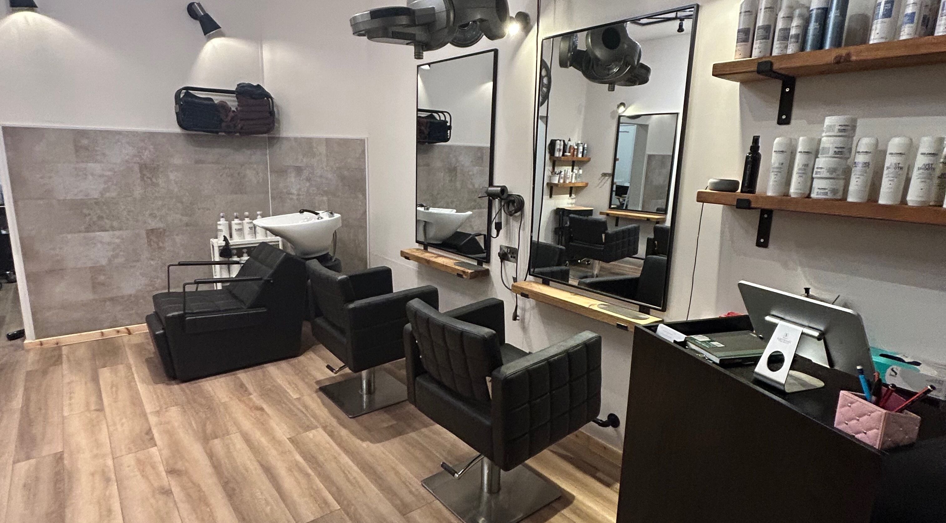 Modern salon interior at Looks Ahead Hairdressers, Innerleithen, Scotland, GB with sleek chairs and styling stations.