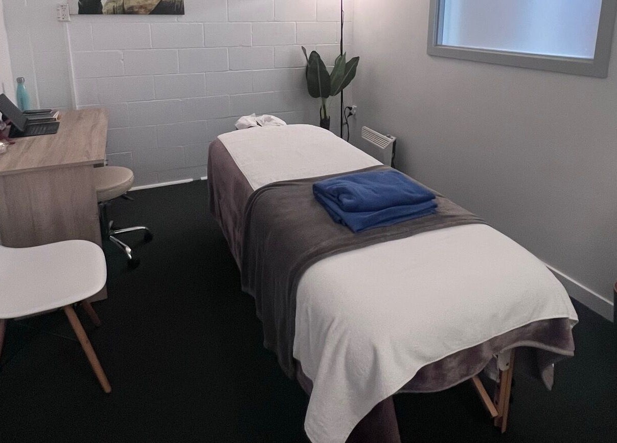 Tranquil massage room at Divine Alchemy Winton, Winton, Southland, NZ, featuring a comfortable table and soft lighting.