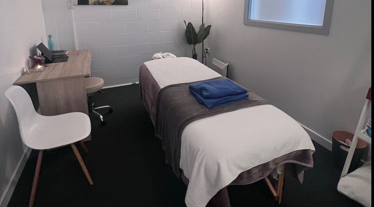 Tranquil massage room at Divine Alchemy Winton, Winton, Southland, NZ, featuring a comfortable table and soft lighting.