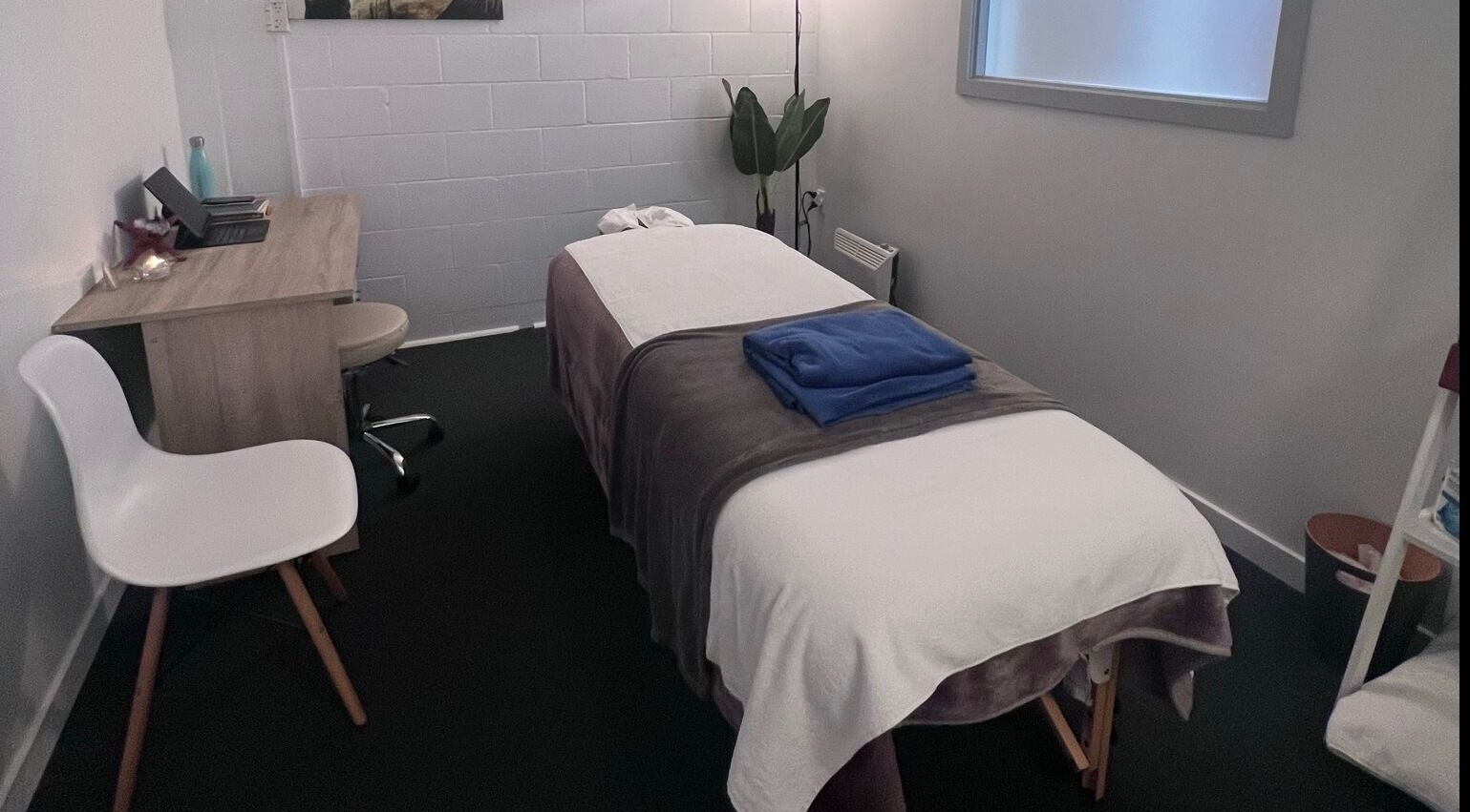 Tranquil massage room at Divine Alchemy Winton, Winton, Southland, NZ, featuring a comfortable table and soft lighting.