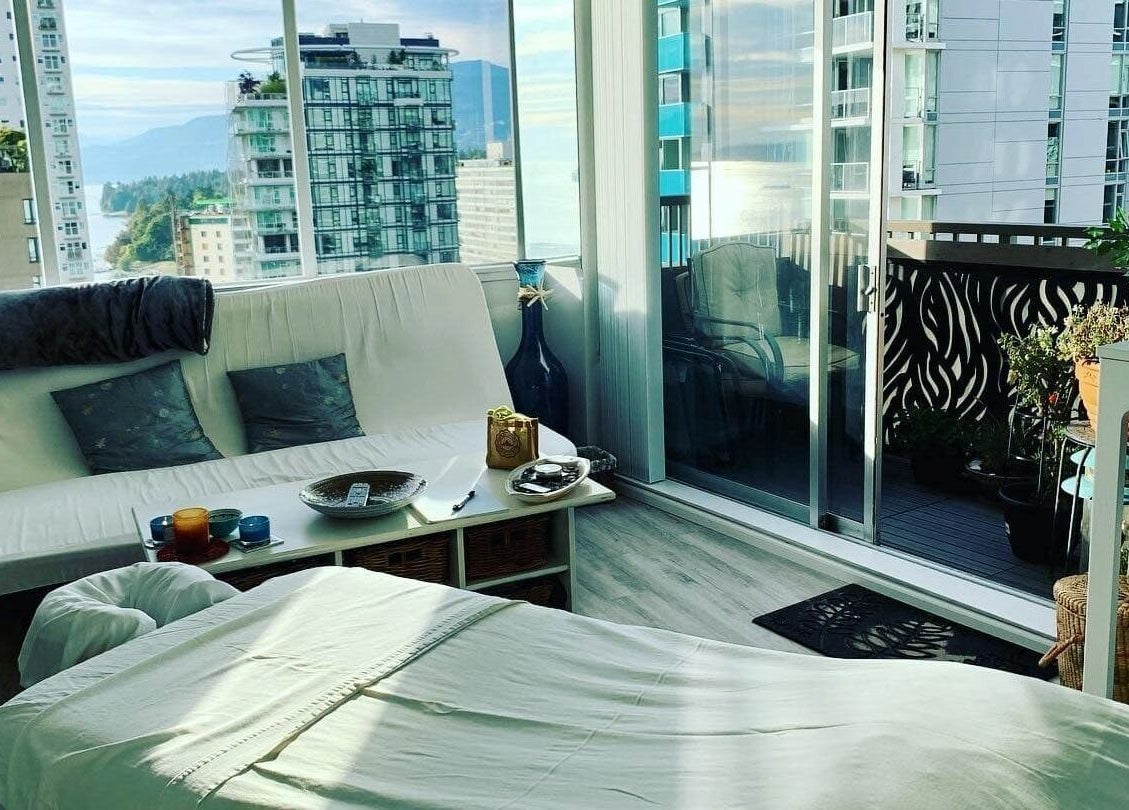 Relaxing massage room at En Vie Mobile Massage, Vancouver, BC, with stunning city views.
