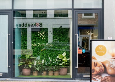 Front entrance of Six Zen Spa in Breda, Noord-Brabant, NL with lush greenery and welcoming signage.