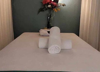 Massage table with rolled towels at Six Zen Spa, Breda, Noord-Brabant, NL, offering tranquility and relaxation.
