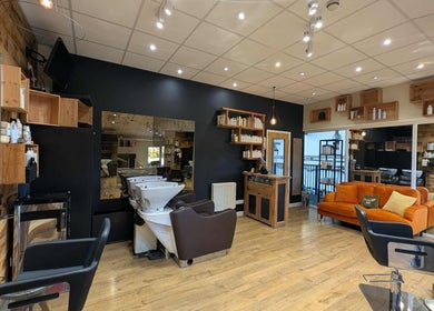 Modern salon interior at Essence in Bourton-on-the-Water, England, GB featuring chic decor and styling chairs.