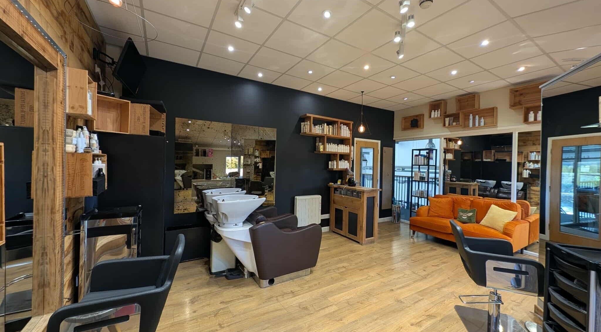 Modern salon interior at Essence in Bourton-on-the-Water, England, GB featuring chic decor and styling chairs.