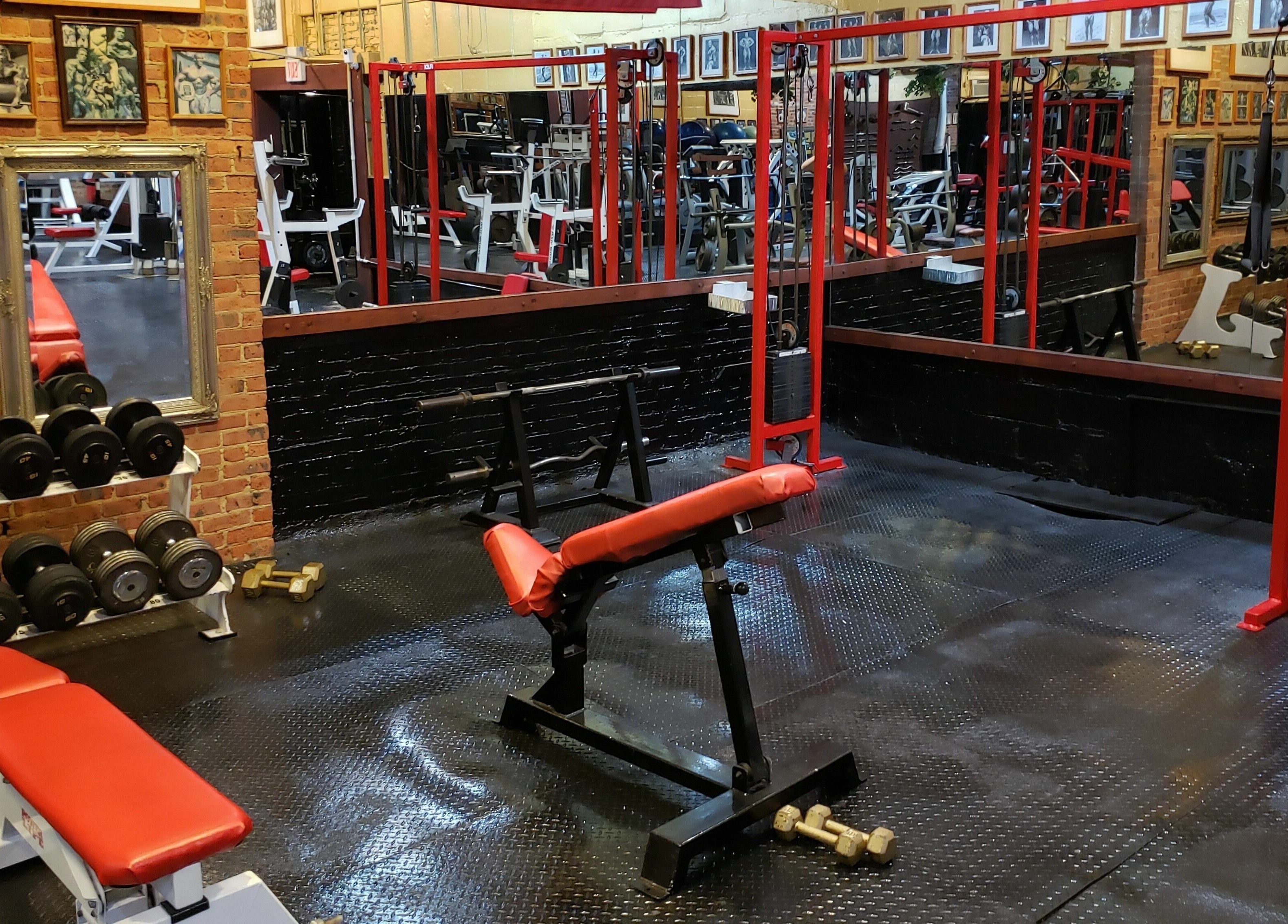 Classic gym interior at Building You, Long Branch, New Jersey, US, featuring equipment and framed artwork.