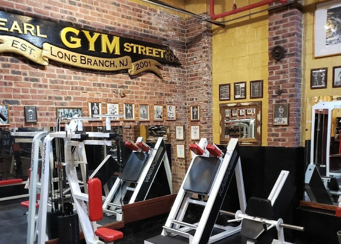 Authentic gym interior at Building You in Long Branch, New Jersey, US, featuring brick walls and workout equipment.