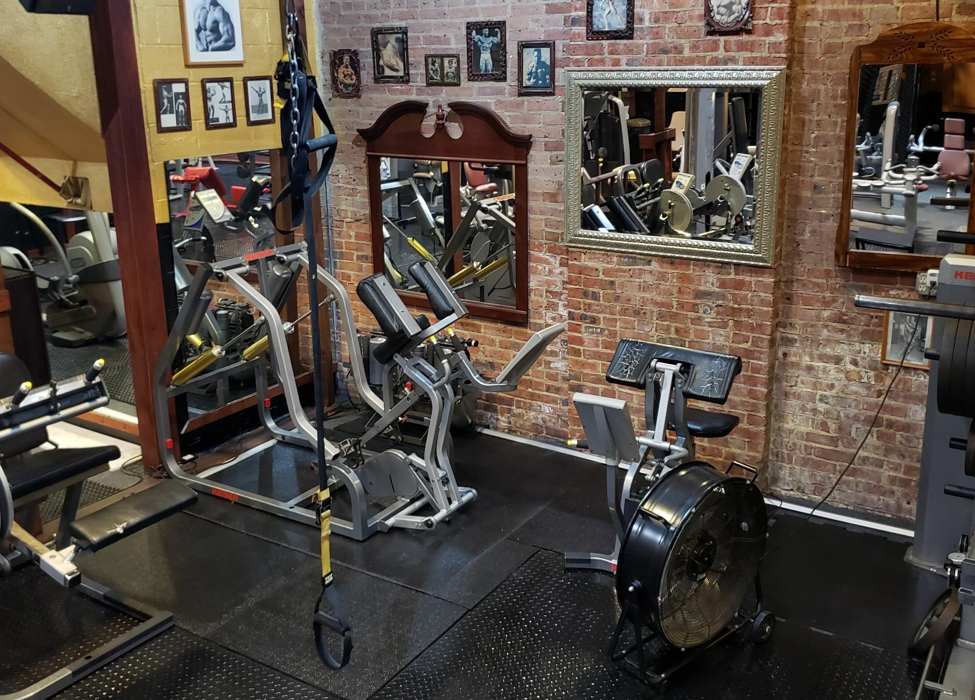 Well-equipped gym at Building You, Long Branch, New Jersey, US, featuring modern fitness equipment and exposed brick walls.