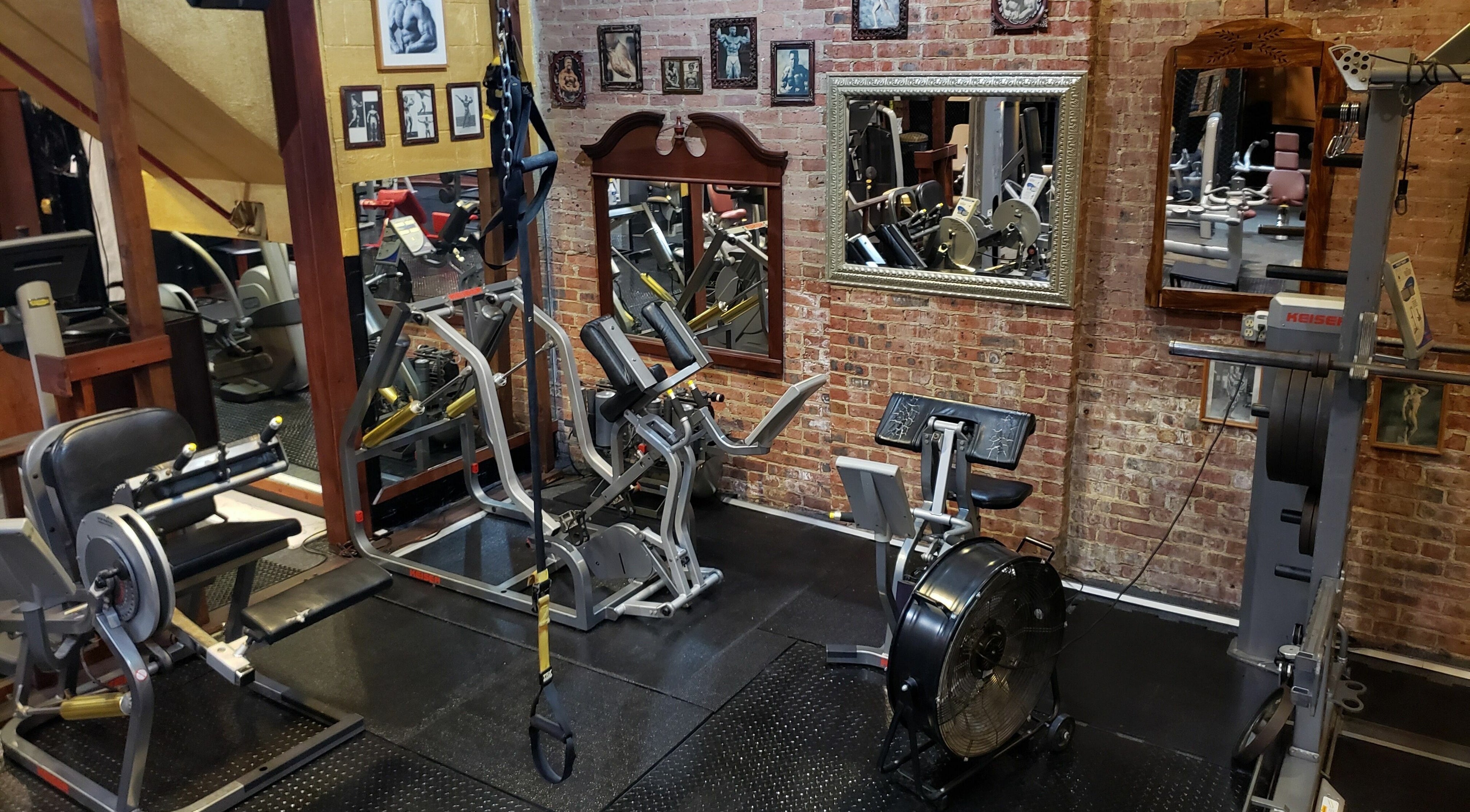 Well-equipped gym at Building You, Long Branch, New Jersey, US, featuring modern fitness equipment and exposed brick walls.