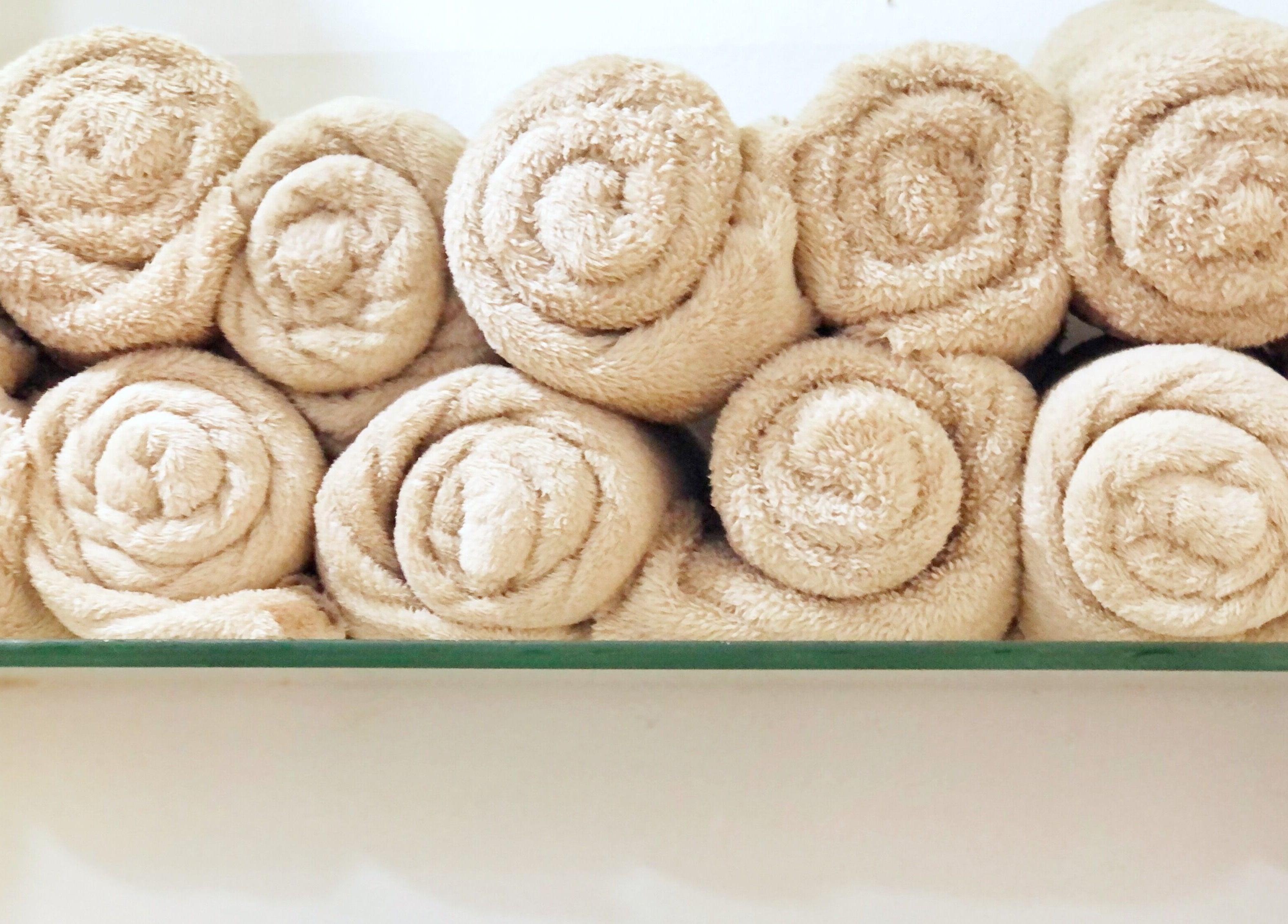 Rolled beige towels at Hairloom Salon, Lugbe, Iddo Tudunwada, Federal Capital Territory, NG for guest comfort.