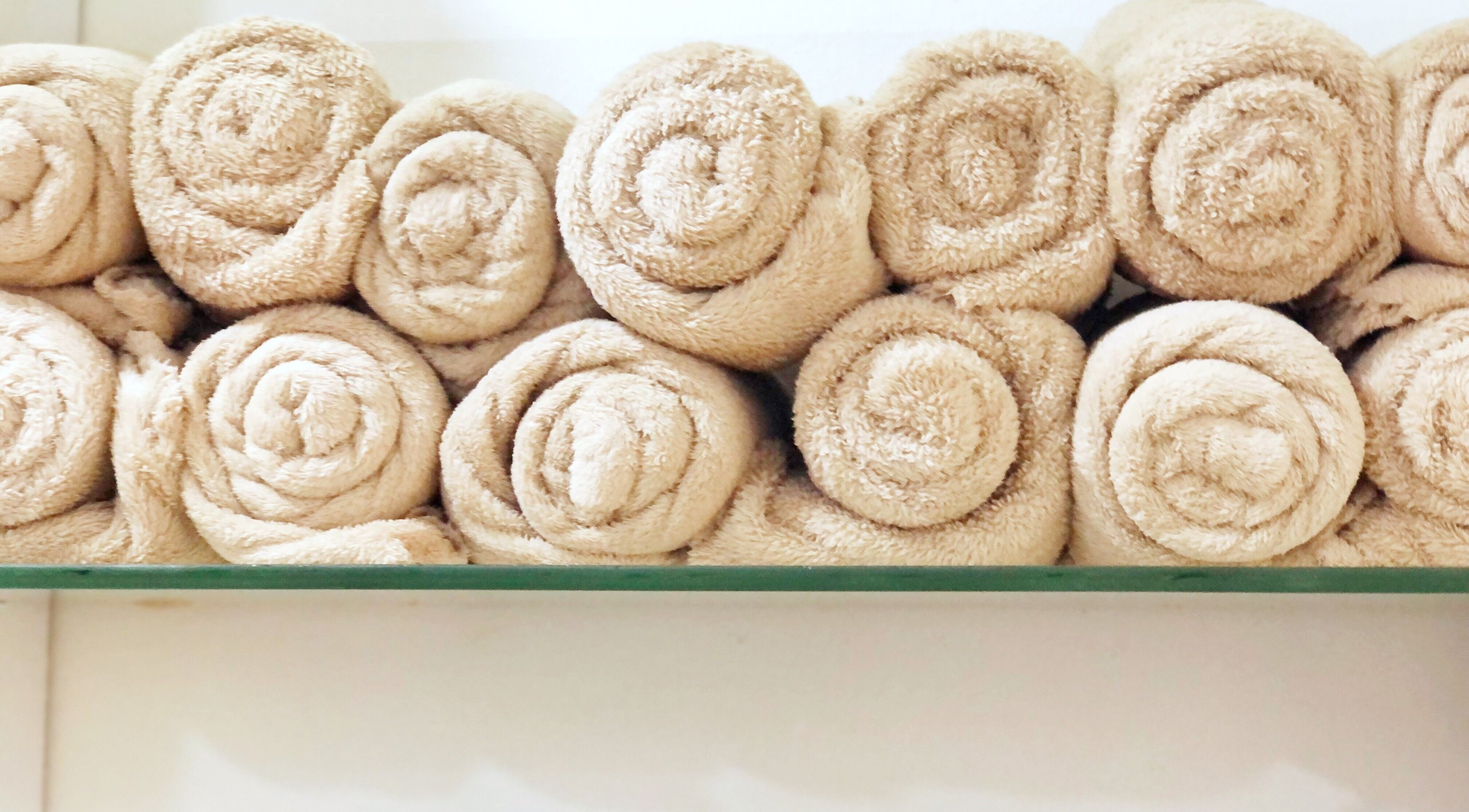 Rolled beige towels at Hairloom Salon, Lugbe, Iddo Tudunwada, Federal Capital Territory, NG for guest comfort.