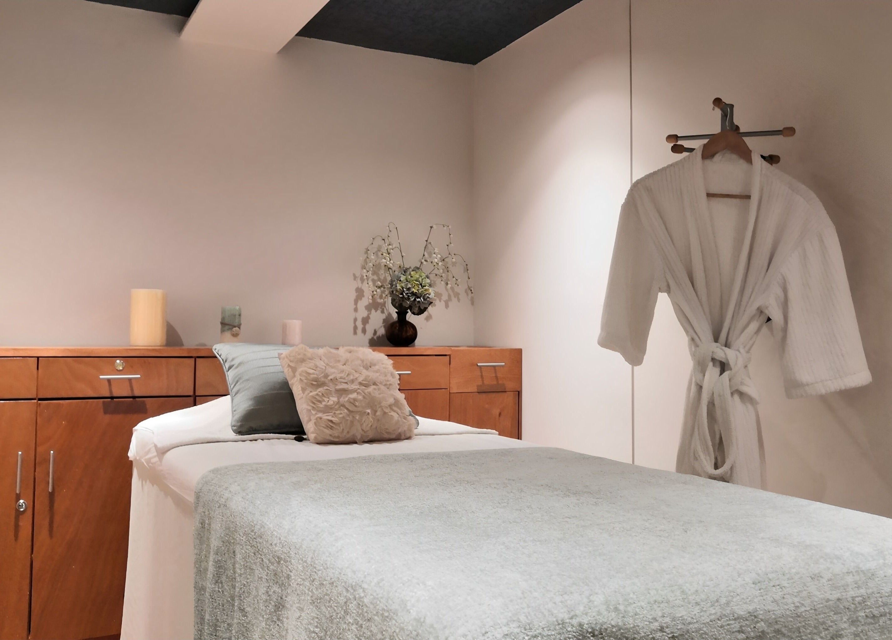 Sala de masajes en Spazio Spa Bienestar Integral, Ciudad de México, MX, con bata blanca y decoración cálida.