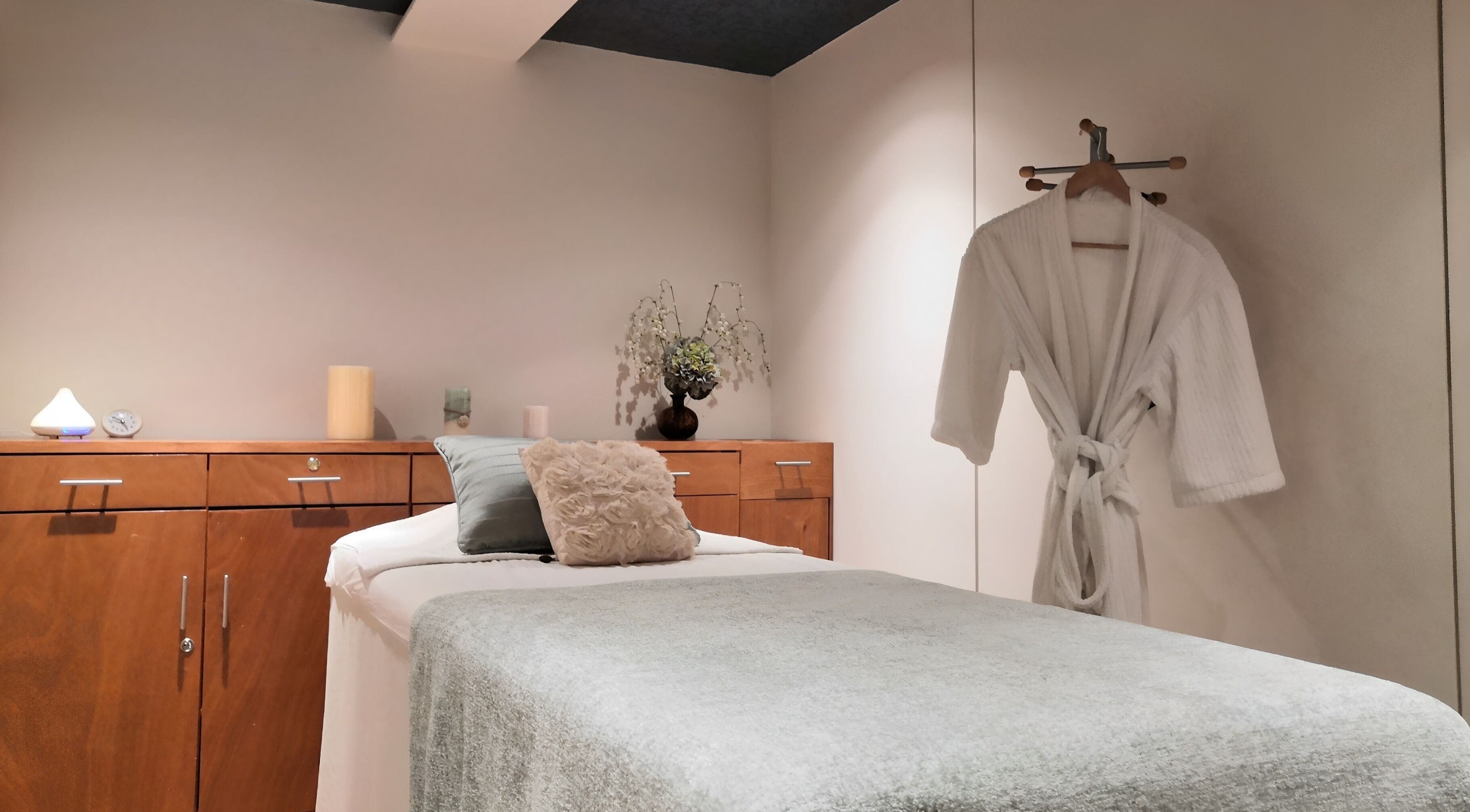 Sala de masajes en Spazio Spa Bienestar Integral, Ciudad de México, MX, con bata blanca y decoración cálida.