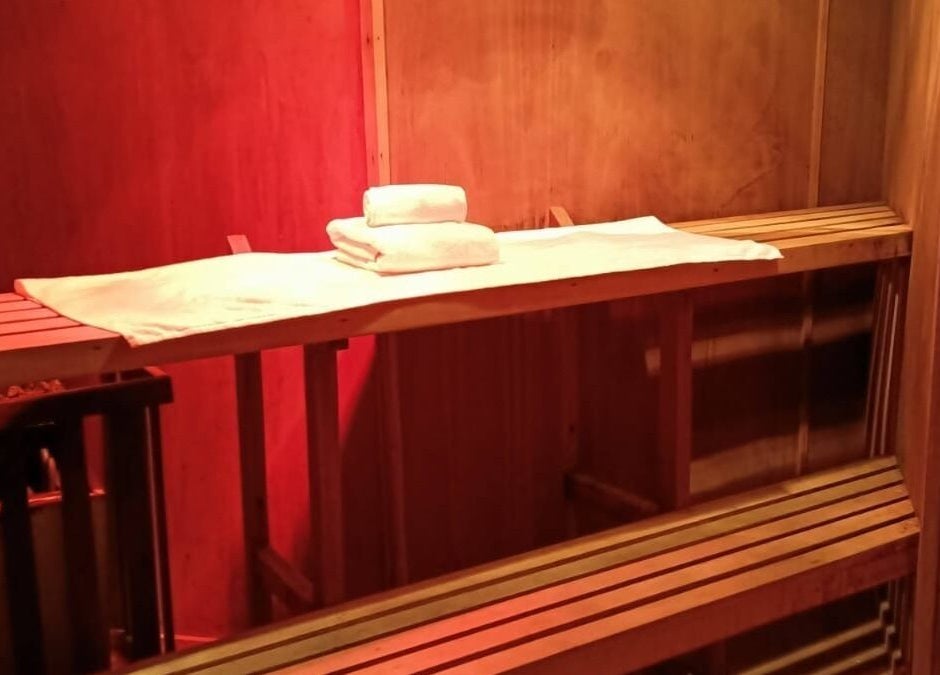 Sala de sauna en Spazio Spa Bienestar Integral, Ciudad de México, Ciudad de México, MX, con toallas sobre banco.