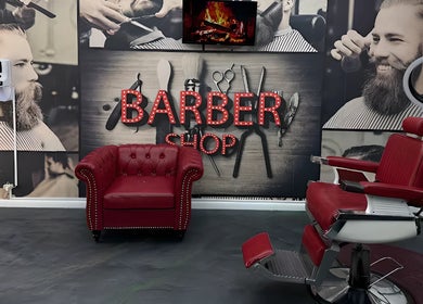 Interior of The Head Office Barber Shop in Nassau, BS, featuring red chairs and vintage decor.