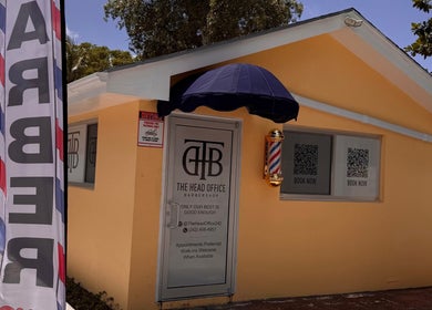 Entrance to The Head Office Barber Shop in Nassau, BS showcasing its welcoming facade and barber pole.