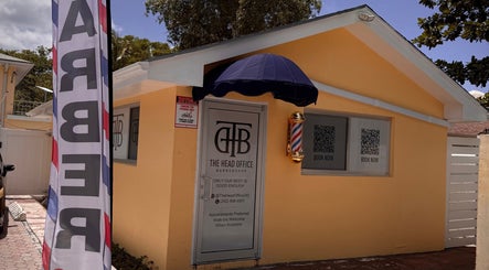 Entrance to The Head Office Barber Shop in Nassau, BS showcasing its welcoming facade and barber pole.