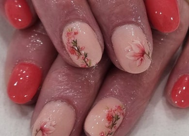 Floral decorated nails with peach and coral polish at Nails by Christina, Bridgwater, England, GB.