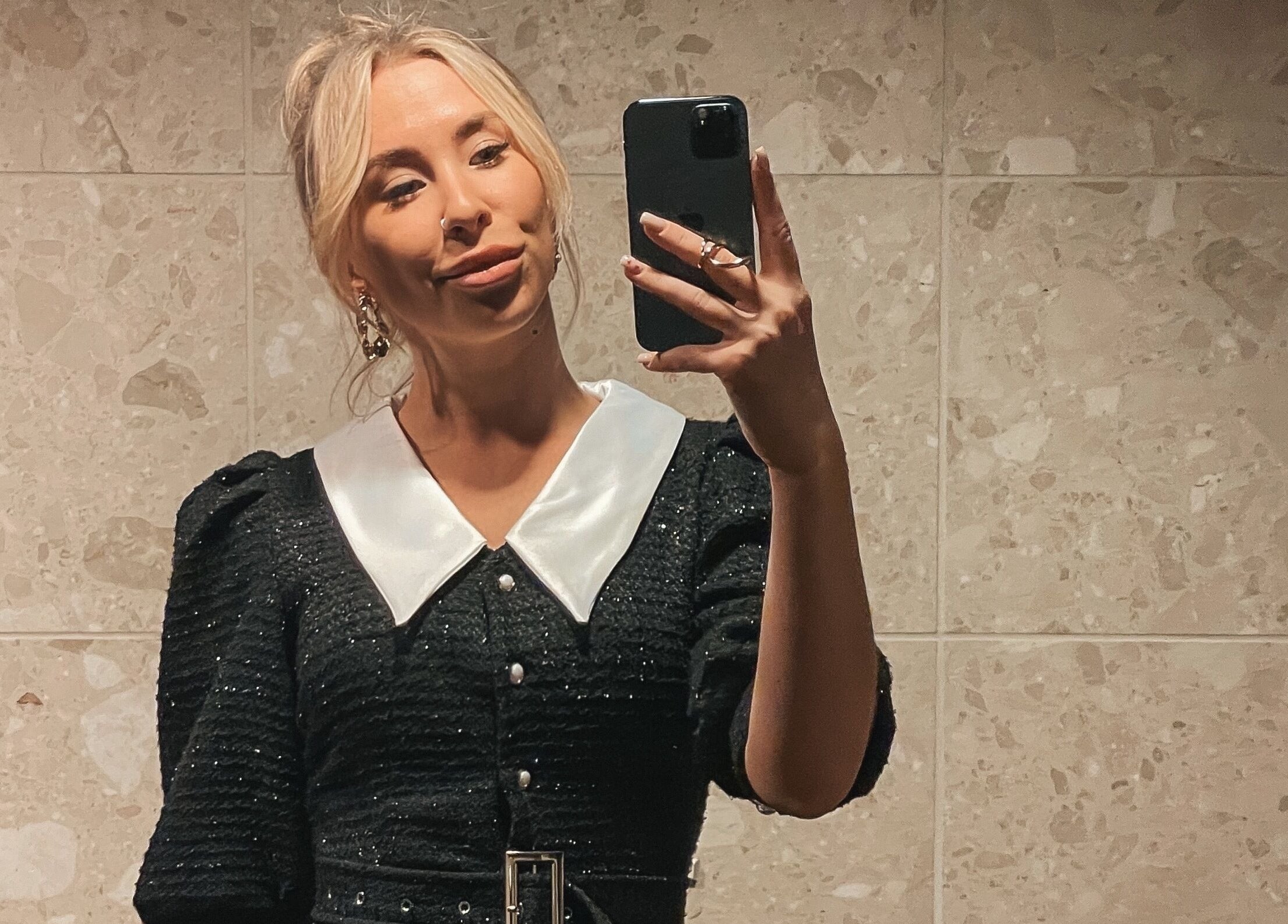 Stylish woman in elegant black dress at MORUHAIR, Tallinn, Harju maakond, EE, capturing a mirror selfie.
