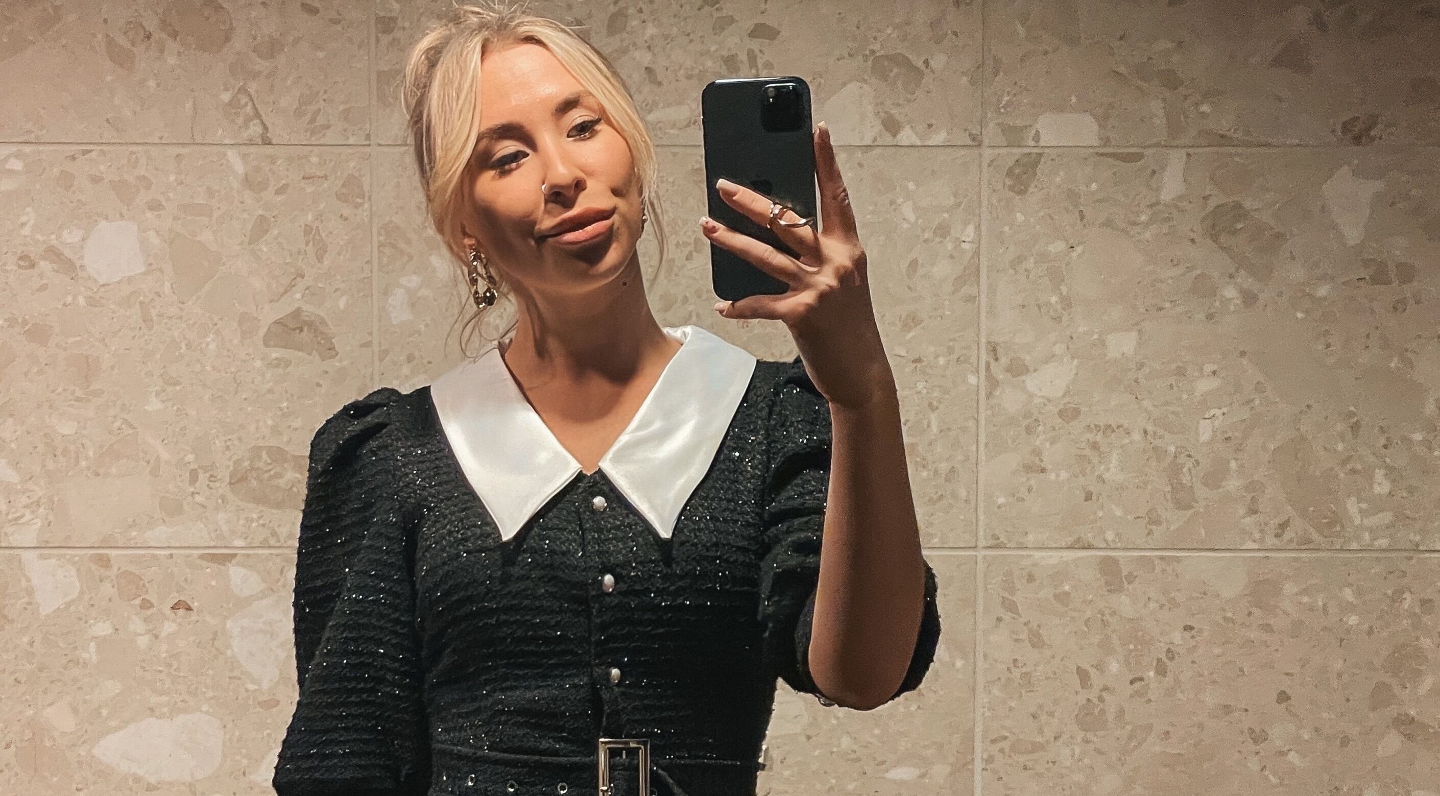 Stylish woman in elegant black dress at MORUHAIR, Tallinn, Harju maakond, EE, capturing a mirror selfie.