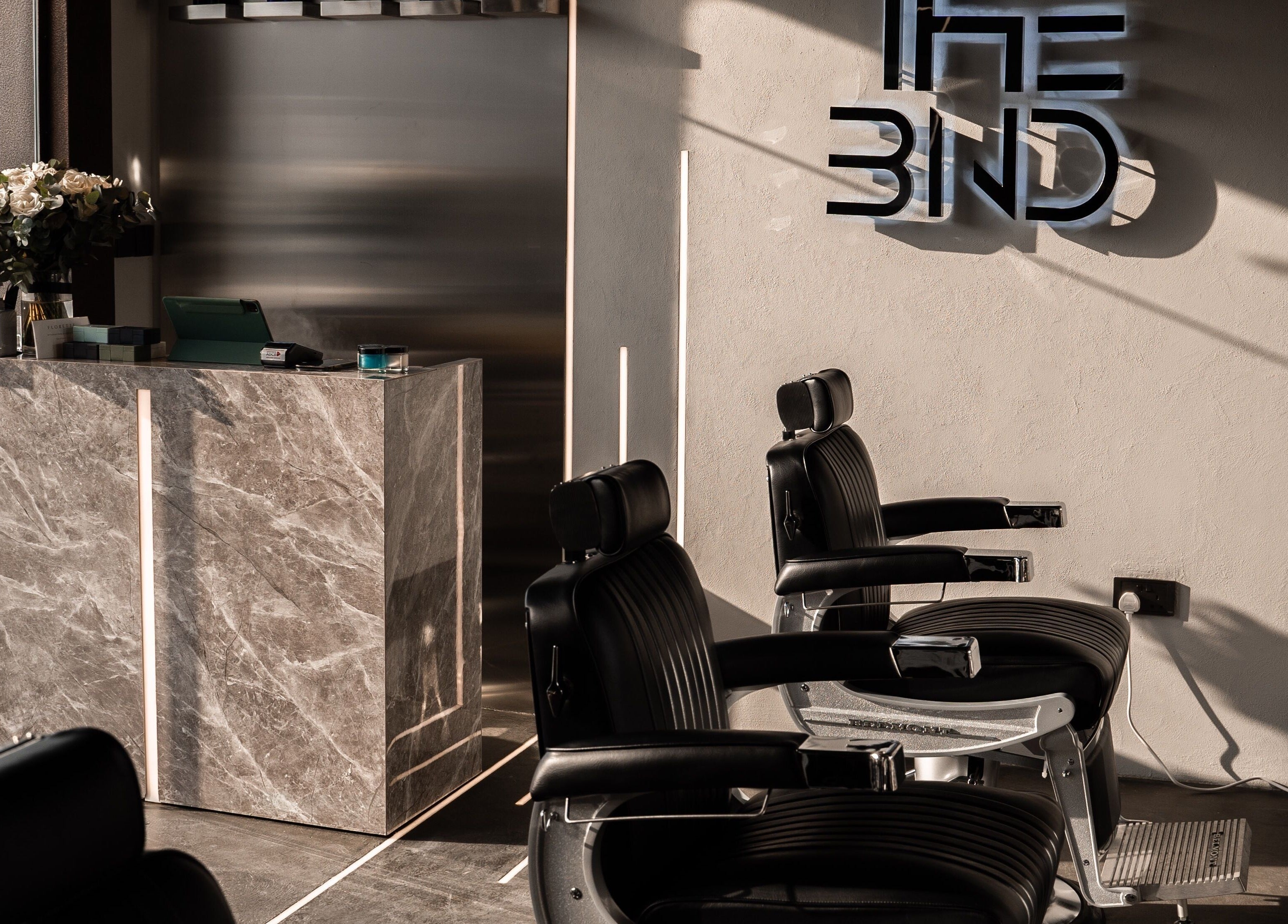 Elegant interior of The BND - Barber Next Door in Abu Dhabi, AE, featuring stylish barber chairs and modern decor.